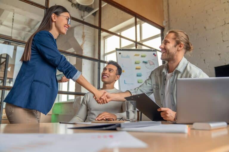 Business people finishing up a meeting. Man shaking hands with female client